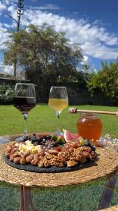 ,,Anna's" Guesthouse في Nizhniy Alvani: طبق من الطعام وكأسين من النبيذ على طاولة