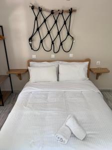 a bed with white sheets and two towels on it at Captain's Studios in Spetses