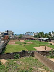 a park with a field of grass and buildings at Sublime Villa in Cotonou