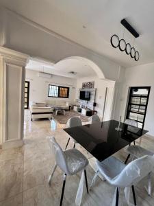 Sublime Villa في كوتونو: غرفة معيشة مع طاولة سوداء وكراسي