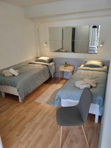 um quarto com 2 camas, uma cadeira e um espelho em Ellivuori Resort Paradise em Sastamala