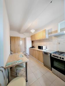 a kitchen with a table and a stove at Apartament Central 3 camere in Craiova