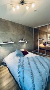 um quarto com uma cama com um edredão azul e espelhos em Fresh apartment 450m to Turku bus station em Turku