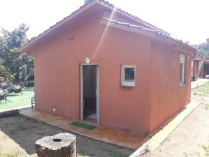 ein rotes Haus mit einer Tür im Hof in der Unterkunft Rural Sant Llop in Tordera