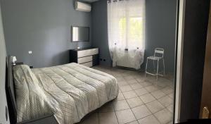 um quarto com uma cama, uma janela e uma cadeira em Casa Perin em Vezzano Ligure