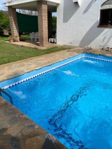 una piscina con agua azul frente a una casa en Villa Fructus en Vejer de la Frontera