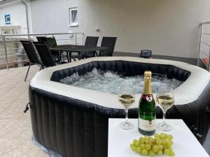 uma banheira de hidromassagem com uma garrafa de champanhe e taças de vinho em Villa Emilly Crikvenica with POOL AND JACUZZI em Dramalj
