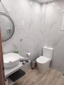 a bathroom with a sink and a toilet and a mirror at Elena's Place, free parking!!! in Perea