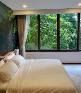 a bedroom with a bed and a large window at Q Kata Residence in Kata Beach