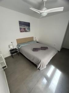 1 dormitorio con 1 cama y ventilador de techo en Balcón azul, en Carboneras