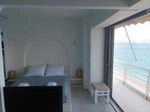 sypialnia z łóżkiem i widokiem na ocean w obiekcie Blue Bliss w mieście Lutraki