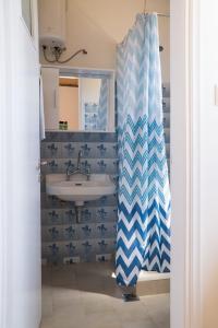 a bathroom with a sink and a shower curtain at Aroma Studios in Argostoli