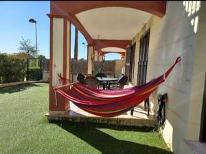 a hammock on a porch of a house at Relax Apartment Costa Esuri in Ayamonte