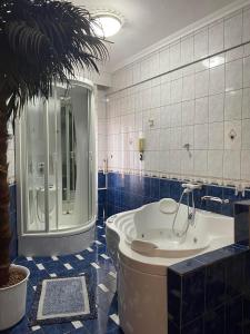 a bathroom with a tub and a palm tree at Rafaela's Apartment in Kavala