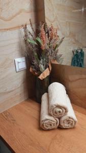 Un mostrador de baño con una toalla y un jarrón de flores en Apartment Botanica en Zvolen