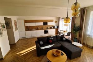 sala de estar con sofá negro y mesa en Apartment Botanica en Zvolen