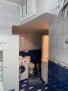 a bathroom with a toilet and a washer and dryer at Rafaela's Apartment in Kavala