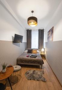 1 dormitorio con cama y mesa con alfombra en ClickTheFlat Wolska Apart Rooms, en Varsovia