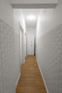 un pasillo con paredes blancas y suelo de madera en ClickTheFlat Wolska Apart Rooms, en Varsovia