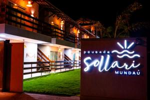 un cartello davanti a un edificio di notte di Pousada Sollari a Mundaú