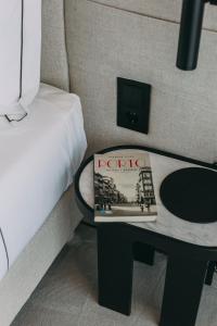 a book sitting on a table next to a bed at Hotels 705 Porto Prime Home in Porto
