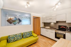 a living room with a yellow couch in a kitchen at Apartmaji Hosnar in Bovec