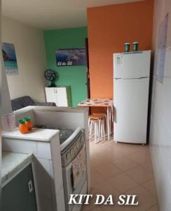 een keuken met een fornuis, een koelkast en een tafel bij KIT DA SIL in Cabo Frio