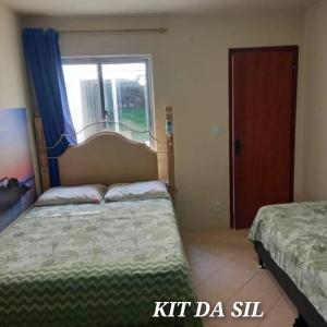 een slaapkamer met 2 bedden en een raam bij KIT DA SIL in Cabo Frio