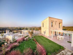 a brick house with a patio and a garden at Luxury Crete Villa Villa Stella Maris Beautiful Landscaped Views & Private Heated Pool Bbq 2 Bedrooms Mylopotamos in Panormos Rethymno +32 photos