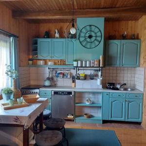 eine Küche mit blauen Schränken und einem Tisch in der Unterkunft Drvena kuca za odmor Cvetkovic brdo 