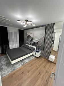 ein Schlafzimmer mit einem Bett und einem Wandgemälde in der Unterkunft Zeus Ultra Apartament in Baia Mare