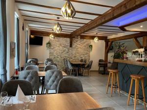a restaurant with tables and chairs and a brick wall at Hotel Restaurant du Moulin in Fleurier