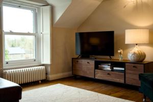 a living room with a flat screen tv on a dresser at The Beeches - Chatsworth Apartment No 5 - Sleep2 in Baslow
