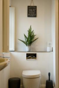 a bathroom with a toilet and a plant on the wall at The Beeches - Chatsworth Apartment No 5 - Sleep2 in Baslow
