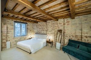 a bedroom with a bed and a couch in it at Anfihouse - Assisi Relais in Assisi