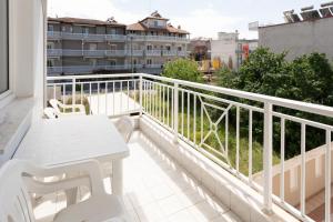 a balcony with a white table and chairs and a building at Villa Zeus INN in Paralia Katerinis