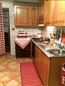 卡斯泰洛迪費耶美的住宿－Villa Indipendente，厨房配有木制橱柜、水槽和炉灶。