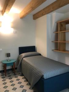 1 dormitorio con cama y mesa pequeña en Appartamento Fronte Laguna Ca’Nonica en SantʼAntonio