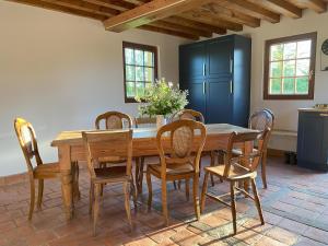 comedor con mesa de madera y sillas en L'Etape Normande, en Sainte-Marguerite-des-Loges