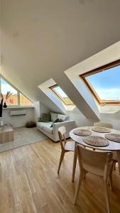 a living room with skylights and a table and chairs at Nida Oasis Apartment in Nida