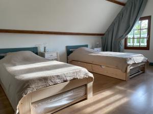 1 dormitorio con 2 camas y ventana en L'Etape Normande, en Sainte-Marguerite-des-Loges