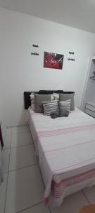 a bed in a room with a sign on the wall at Meu lugar de Descanso in Cabo Frio