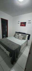 a large bed in a white room with avertisement at Meu lugar de Descanso in Cabo Frio