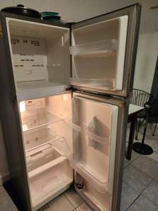 シワタネホにあるBudget friendly / Homestay / with private balconyのキッチンにあるドアが開いたままの空の冷蔵庫