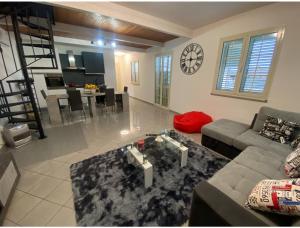 a living room with a couch and a clock on the wall at mario's home in Pula