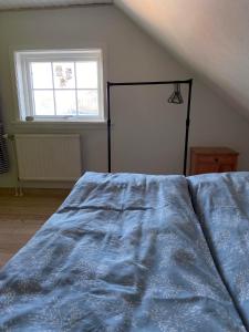 um quarto com uma cama com um edredão azul e uma janela em Seaside Cottage em Oyndarfjørður