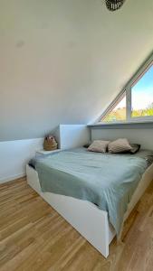 奈達的住宿－Nida Oasis Apartment，白色客房的一张床位,设有两个窗户