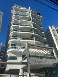 ein hohes weißes Gebäude mit einem Schild davor in der Unterkunft Ejecutivo penthouse en santo domingo in Santo Domingo