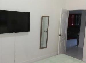 a flat screen tv on a wall with a mirror at Mi Casa Comfort Estate in Portmore
