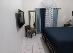 1 dormitorio con cama azul y espejo en Mi Casa Comfort Estate, en Portmore